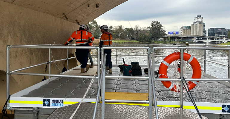 Bridge inspection engineers on floating modular dock on the Yarra River to inspect bridge